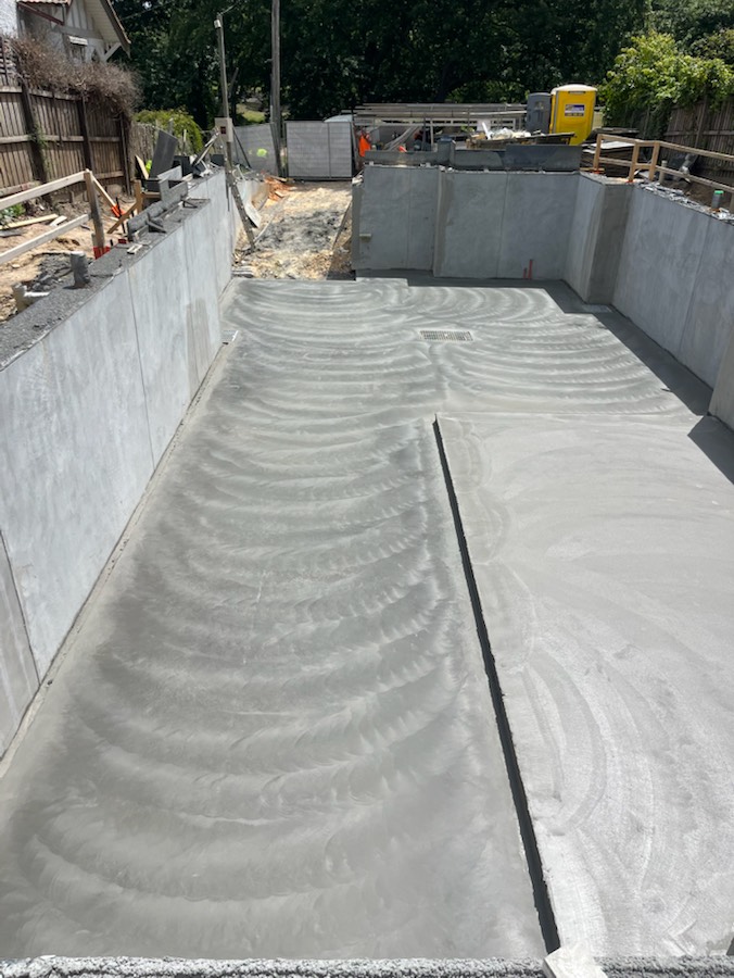 A finished concrete slab running between concrete walls