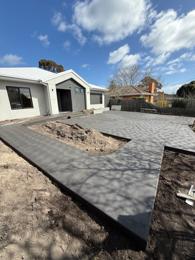 Charcoal concrete paths laid around a new house