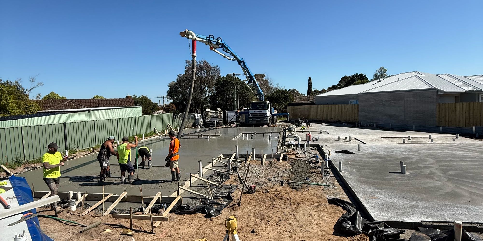 The crew pouring a house slab with a concrete boom pump